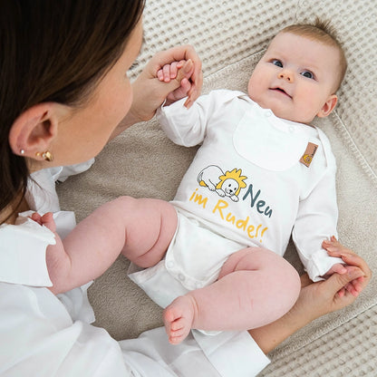 Baby mit bedrucktem Body und Kräuterpad-Tasche