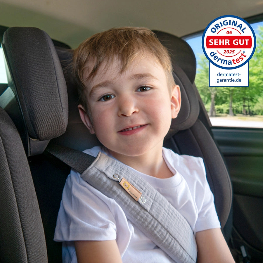 Kind im Auto mit Gurtschoner - dermatest Siegel mit Note SEHR GUT