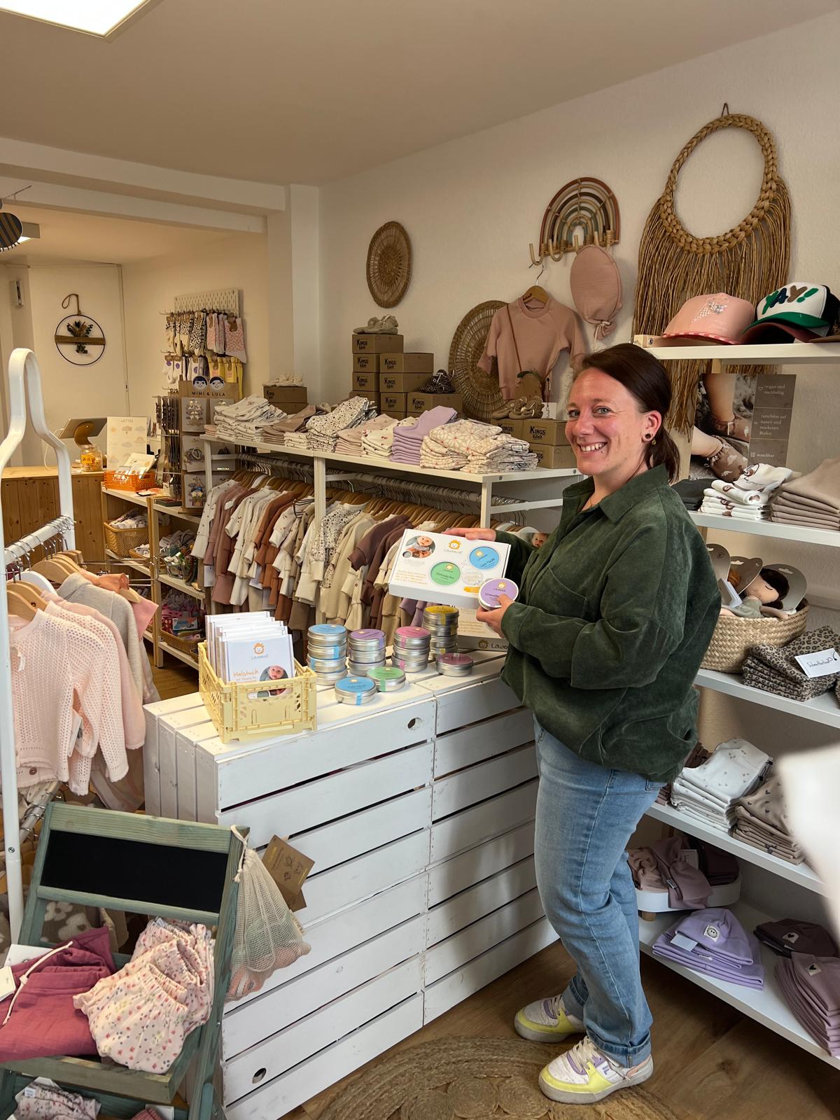 Schmetterlina - Verkäuferin im Baby-Shop mit Löwenkind Einsteigerbox in der Hand